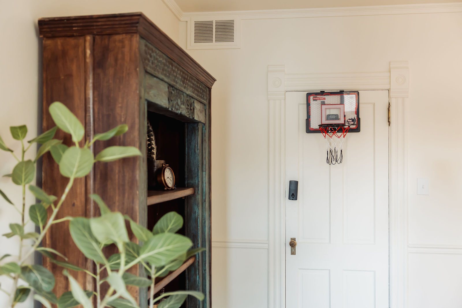 A small basketball hoop on the office door, next to Dr. Rosen's painted bookshelf