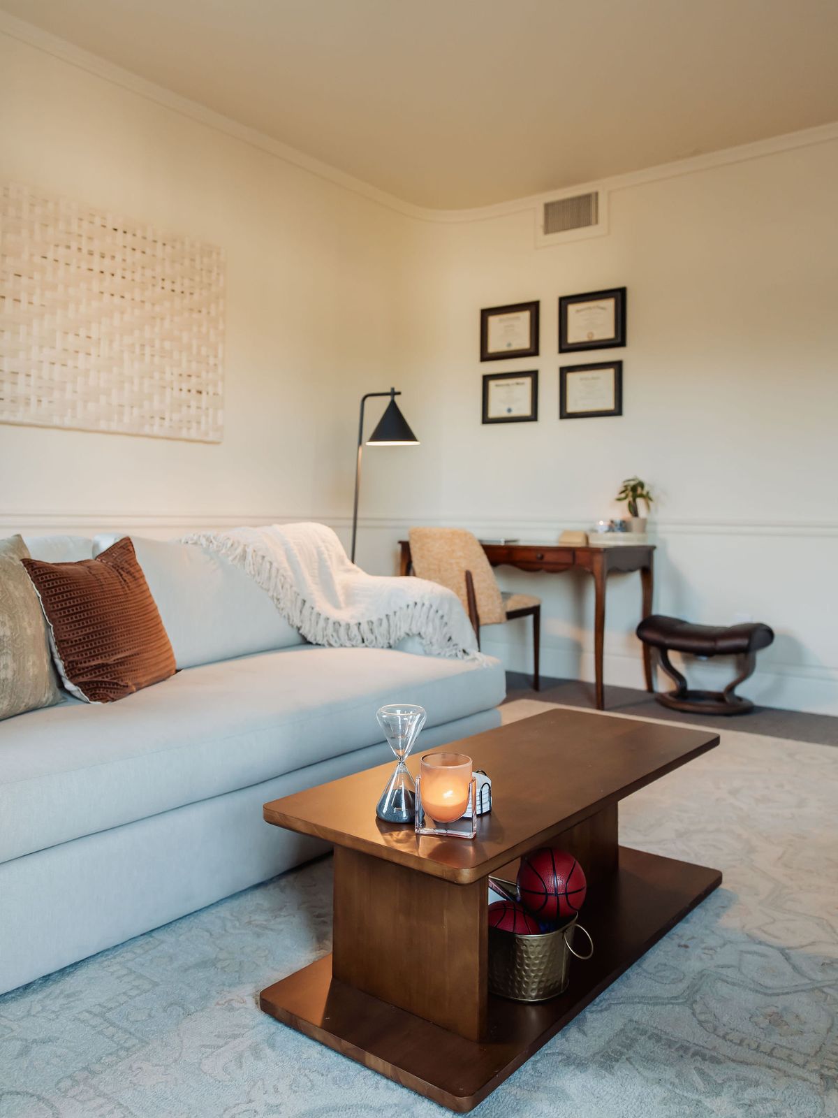The sofa and coffee table, with a candle and an hourglass on the table