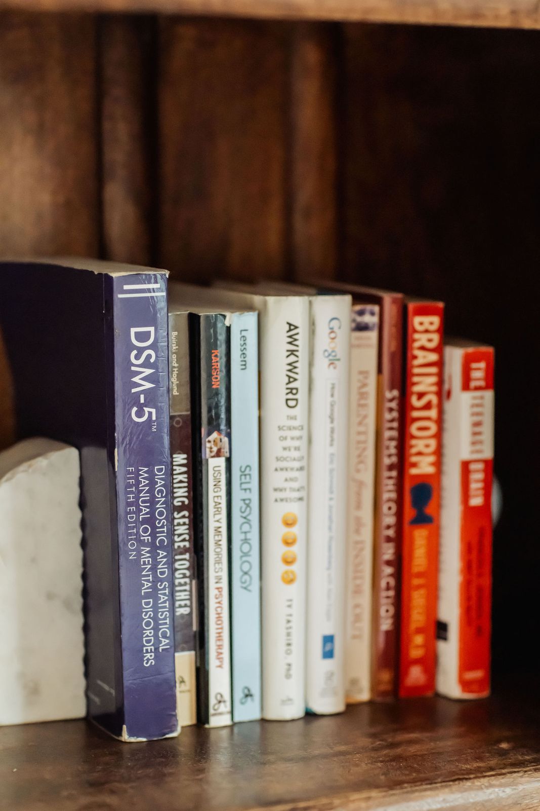 The DSM-5 and other psychology books on the office shelf